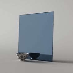 a mirror and bowl sitting next to each other