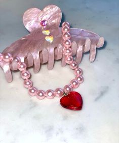 Super Glazed and Super glossy! This is our take on the classic pearl necklace -- choose between pink or elegant white glass pearls, and a cherry red heart or milky white heart charm! Both equally juicy, of course. Pink pearl option measures at around 15" long with extender, and white pearl option available in both 15" and 17" long with extender. Pink Choker For Valentine's Day Gift, Pink Pearl Necklace With Heart Beads Gift, Pink Heart-shaped Choker For Gifts, Pink Heart-shaped Choker As A Gift, Pink Heart Choker As Gift, Pink Heart-shaped Choker Gift, Pink Pearl Jewelry With Heart Charm, Pink Heart-shaped Choker For Valentine's Day, Pink Heart-shaped Pearl Necklace