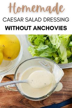 homemade caesar salad dressing without anchovies in a glass measuring cup on a cutting board with lemons and lettuce