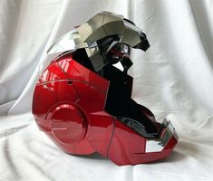 a red motorcycle helmet sitting on top of a white sheet