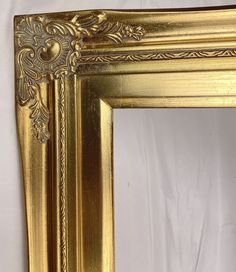 an ornate gold framed mirror on a white background with the reflection of it's frame