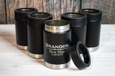 four black and silver travel mugs sitting on top of a table