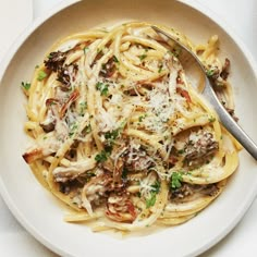 a white bowl filled with pasta and mushrooms