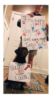 a man holding two signs with dogs on them