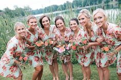 a group of women standing next to each other on top of a lush green field