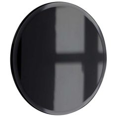 a round mirror with the reflection of a window in it's center, on a white background