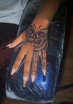 a woman's hand with a skull tattooed on it