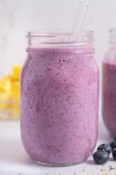 blueberry smoothie in a mason jar with a straw