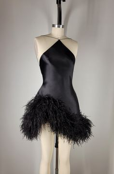 Fin  Black silk sueded satin backless halter, tapered neckline suspended by dainty satin cord. Asymmetrical hem embroidered with custom dyed pure ostrich feathers. Invisible zipper at center back.    Color and length may be customized. May be paired with custom designed sleeves and gloves. FAQS HOW LONG DOES THE PROCESS TAKE? Each look is custom made to order with precise measurements. Ideally requiring a minimum of 8 weeks.  If faster delivery is needed, a priority reservation can be placed with this listing: https://www.etsy.com/listing/1606891070/priority-reservation WHAT MEASUREMENTS ARE REQUIRED?  Your unique measurements are the most important part of the process. These measurements will be needed to begin work on your garment. * BUST (Around the fullest part of the chest, including Formal Mini Dress Outfit, Black Salsa Dress, Waist Drop Dress, Edgy Cocktail Attire, Custom Made Birthday Dress Black Women, Asymmetrical Mini Dress, Ostrich Feather Outfit, Black Dress High Fashion, Dress To Wear To A Wedding As A Guest