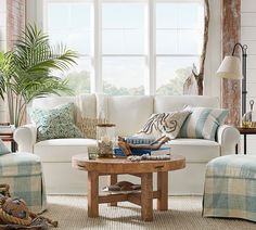 a living room filled with lots of furniture next to a large white couch and chair