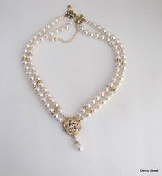 "This romantic double strand necklace has a victorian style rose pendant with clear stones set on an antique gold filigree. I have used Swarovski pearls in ivory/cream. All the Swarovski crystals in the pendant are handset by me. Pearls measure 8 mm in both strands accented with rhinestone beads. Rhinestone pendant is just under 1\" in diameter. Necklace is 17\" long inner strand. Finished off with antique gold finish filigree clasp adorned with Swarovski crystals. It comes with a 2\" extender c Double Strand Gold Wedding Jewelry, Gold Double Strand Wedding Jewelry, Double Strand Gold Jewelry For Wedding, Gold Double Strand Necklace For Wedding, Elegant Double Strand Necklace For Weddings, Classic Double Strand Wedding Necklaces, Gold Double Strand Pearl Necklace For Wedding, Double Strand Pearl Chain Jewelry For Weddings, Double Strand Pearl Chain For Wedding