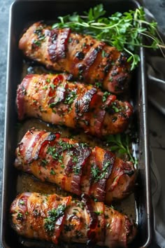 chicken wrapped in bacon and garnished with herbs