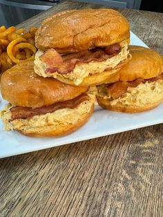 three breakfast sandwiches are stacked on top of each other with macaroni and cheese