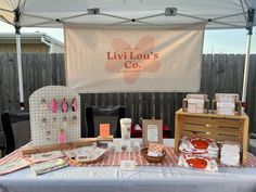 the table is set up with various items for sale on it's own stand