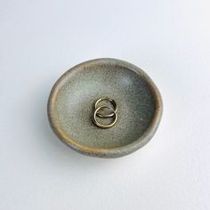 a small ceramic bowl with two rings on it