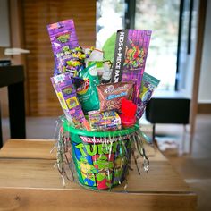 a basket filled with candy and snacks on top of a wooden table