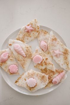 a white plate topped with pieces of cake covered in frosting and pink candies