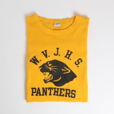 This vintage 1970s era Champion Lastone print collegiate Football Style t-shirt features excellent graphics in a bold yellow-and-black coloration. This great example comes from West Valley Junior High School and includes their school's illustrative panther mascot. Sizing Fits about a medium with potential to stretch out further if desired. Provided below are measurements to aid in sizing, please use them as a reference and do not rely solely on the tag. Measurements 37" chest / 18.5" pit to pit Vintage Screen Print Tops For College, Yellow Tops With Letter Print For Sports Events, Vintage Graphic Print Tops For College, Yellow Graphic Print Tops For Sports Events, Vintage Letter Print Tops For College, Yellow Letter Print Top For School, Retro Tops With Logo Print For College, Retro Yellow Tops With Screen Print, Vintage Crew Neck Tops For School