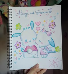 someone is holding up a drawing of two rabbits in front of some stuffed animals and flowers