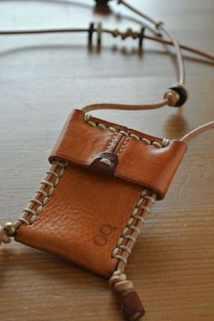 a brown leather case is attached to a necklace