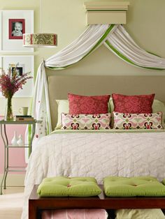 a bed with pink and green pillows on top of it