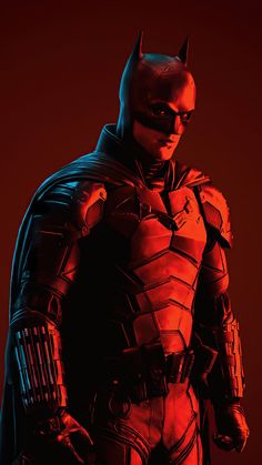 the dark knight batman standing in front of a red background