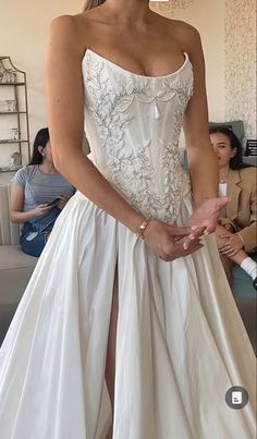 a woman in a white dress posing for the camera