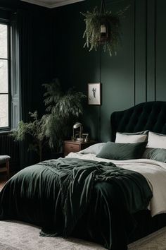 a bedroom with dark green walls and white bedding, potted plants on the wall