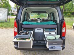 the back end of a van with an open trunk and two trays on it