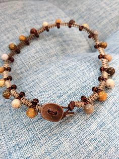 Handcrafted macrame anklet with brown leather core, round semiprecious stone beads, and variegated hemp cording.  Approximate ankle width: 10"; see photos for sizing. Bohemian Brown Beaded Bracelets With Sliding Knot, Bohemian Brown Beaded Bracelet With Sliding Knot, Casual Beaded Bracelet With Macrame And Round Beads, Casual Macrame Beaded Bracelet With Round Beads, Casual Beaded Bracelet With Macrame, Bohemian Brown Braided Bracelets Hand-strung, Bohemian Brown Hand-strung Braided Bracelets, Brown Beaded Bohemian Braided Bracelet, Adjustable Brown Beaded Hippie Bracelets