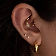 a woman's ear is shown with three different types of piercings