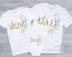 two shirts that say mom, dad and one with butterflies on the front in gold foil