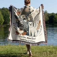 a woman is holding up a blanket that says love you mama bear