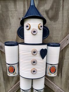 a white and blue tin can robot holding two cups