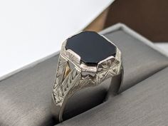 14k Solid White Gold Onyx Signet Ring Beautiful etched design It's a huge and heavy statement ring The bold and eye-catching vintage ring has a striking midnight  black onyx. It has a beautiful handcrafted design and is one of a kind.  Hallmarked 14k Gold has been verified.  Size 9 1/2 RESIZABLE  Weight 6.9 grams 3.9 mm band width 15.0 mm wide Gemstones: Onyx 13mm x 10mm All our jewelry is adequately washed and disinfected to ensure customers get clean items with every order. Comes in a beautiful gift 🎁 box Luxury Onyx Signet Ring For Anniversaries, Luxury Black Engraved Ring For Formal Occasions, Formal Black Engraved Ring, Formal Black Engraved Jewelry, Black Elegant Engraved Ring For Formal Occasions, Elegant Black Engraved Ring For Formal Occasions, Black Engraved Ring With Polished Finish For Formal Occasions, Formal Black Engraved Ring With Polished Finish, Formal Black Engraved 14k Gold Ring