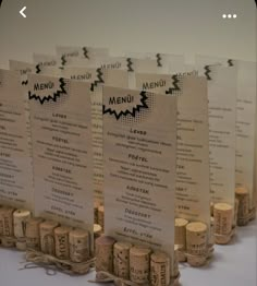 there are many wine corks on the table with menu cards in front of them