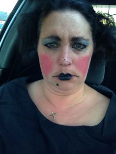 a woman with makeup on her face sitting in a car