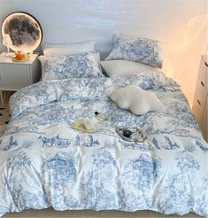 a bed with blue and white comforter in a bedroom next to a night stand