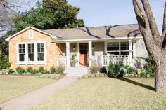 a small brick house with trees in the front yard