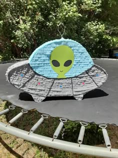 an alien pinata sitting on top of a trampoline