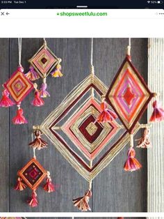 some tassels hanging from a wooden wall with red and pink decorations on it