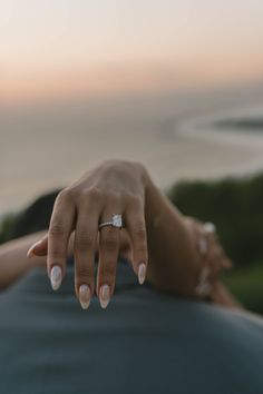 a close up of a person's hand with a ring on their finger