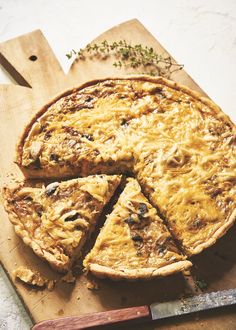 there is a pie on the cutting board with a knife