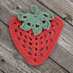 two crocheted strawberries sitting on top of a wooden table