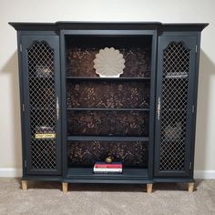 a black bookcase with glass doors on top