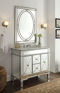 a bathroom vanity with a mirror above it and lights on the wall next to it