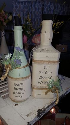 two bottles with flowers on them are sitting next to each other, one is labeled i'll be your shot cup whine