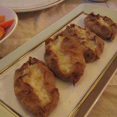 three trays with different types of food on top of each other, including carrots and bread