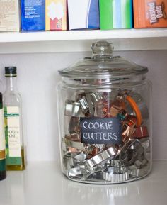 a glass jar filled with lots of different types of condiments on top of a counter