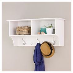 a hat and coat hanger on a white wall with two coats hanging from hooks